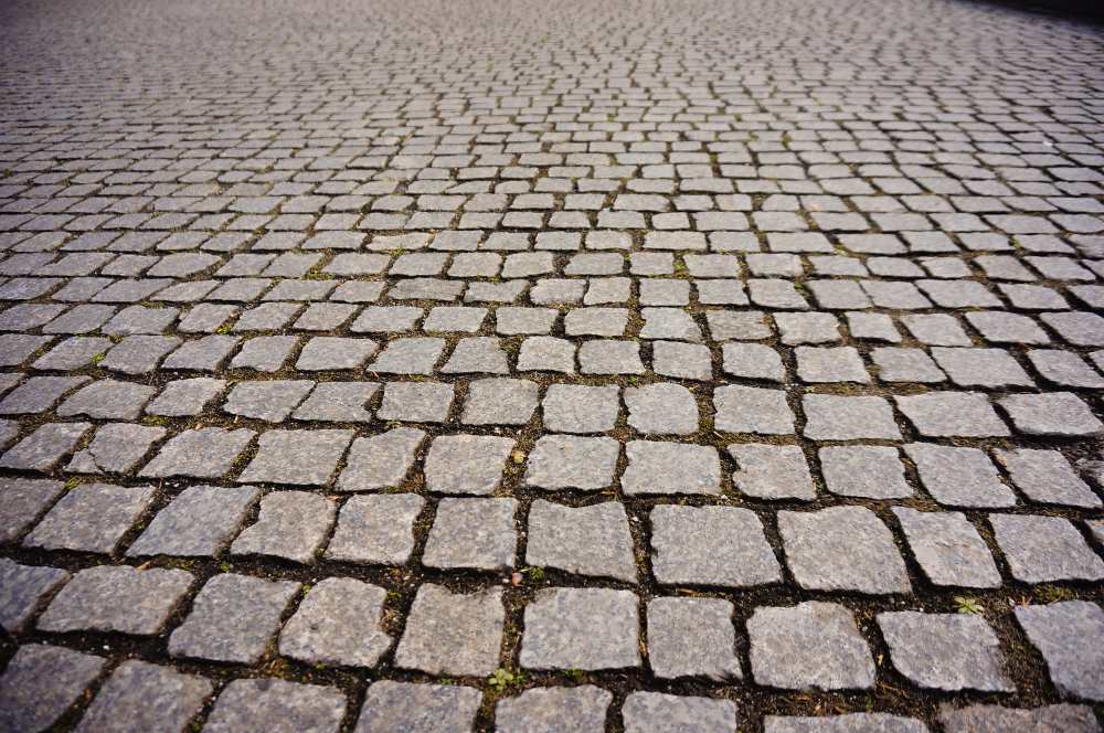 Pavés en béton gris posés en motif régulier sur une chaussée urbaine